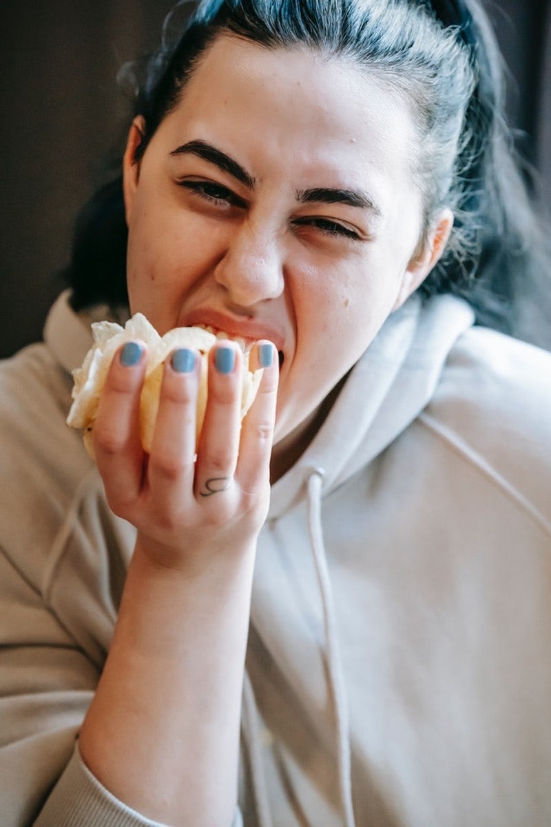 Woman devouring a handful of chips